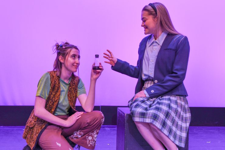 Puck, played by Katie Dingle, shares the potion "Love-entitledness" with Helen, played by Abby Cardenas. Photo: Taryn Gaulke