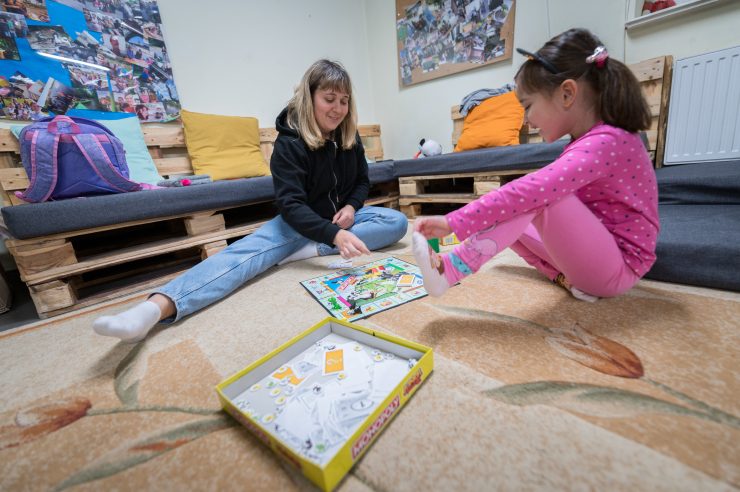 Mother and daughter playing board game at church in Poland