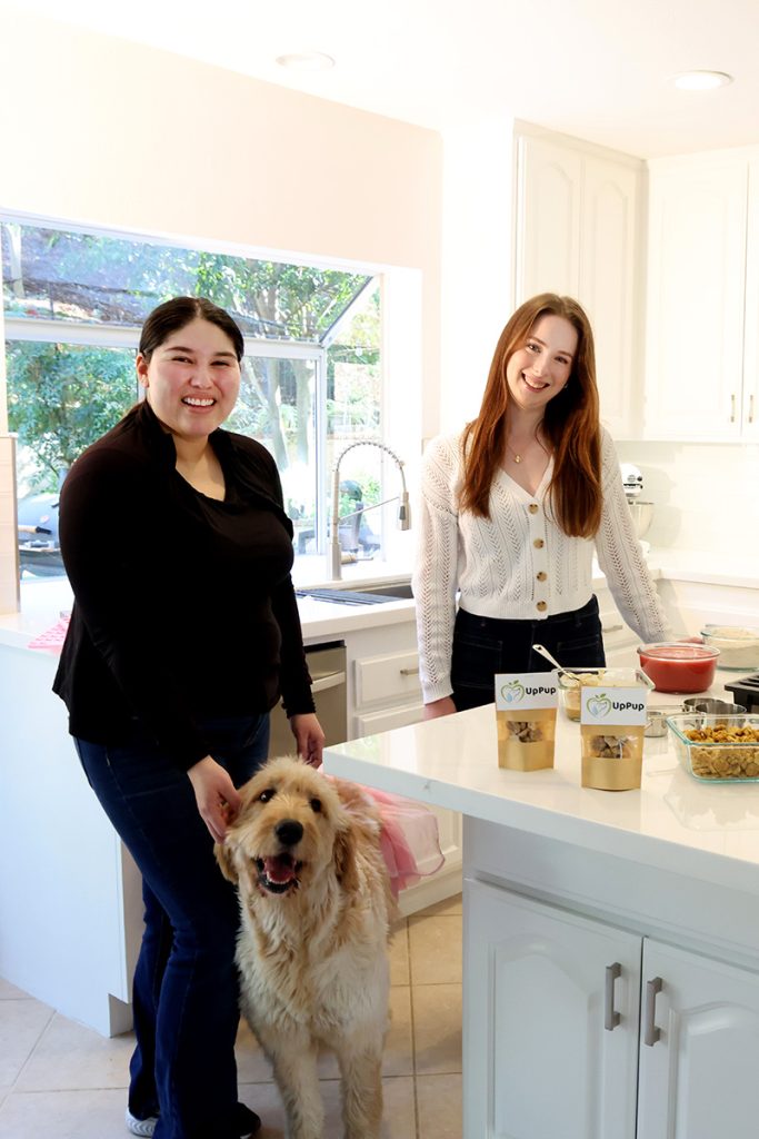 Rosie Baker and Princesa Martinez with a yellow dog
